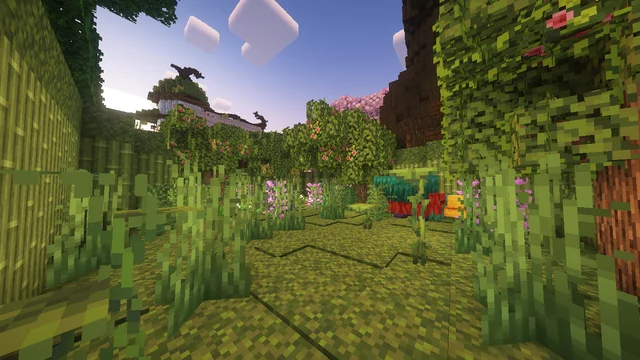 A stone-and-grass path bordered by bamboo, leafy plants, and flowers.
